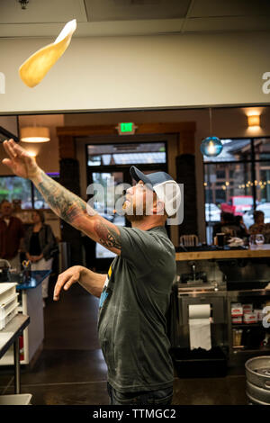 USA (Oregon, Bend, Pacific Pizza et Brew, chef de pizza tossing pâte Banque D'Images