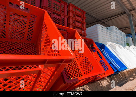 Caisses en plastique empilées en entrepôt - rouge, bleu et blanc Banque D'Images