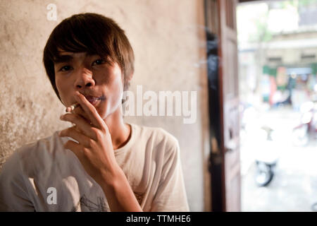 VIETNAM, Hanoi, restaurant Pho Gia Truyen, également connu sous le nom de 49 Bat Dan, portrait d'un jeune cuisinier ayant une cigarette et prendre une pause Banque D'Images