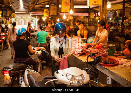 VIETNAM, Hanoi, une jeune femme achète la viande d'un boucher dans le Chau Long Market Banque D'Images