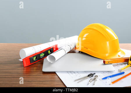 Plans de construction avec des outils et un casque sur fond clair Banque D'Images