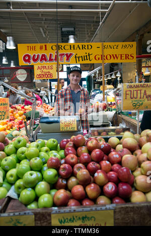 CANADA, Vancouver, Colombie-Britannique, jeune homme vend des pommes à la Granville Island Public Market Banque D'Images