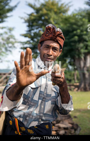 L'INDONÉSIE, Flores, un homme témoigne de l'une de ses poses de boxe traditionnelle dans son village Kampung dans Tutubhada Rendu Banque D'Images