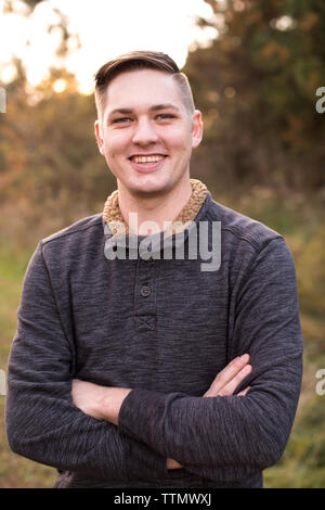 Smiling 20 Year Old Man est au coucher du soleil en toute confiance sur le sentier Banque D'Images