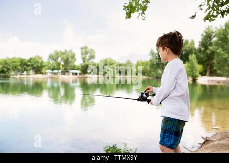 Vue latérale du garçon de pêche dans le lac Banque D'Images