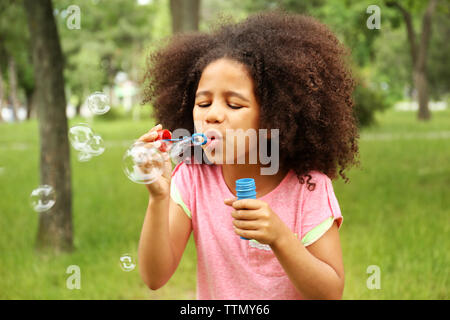 De petite fille soufflant des bulles de savon Banque D'Images