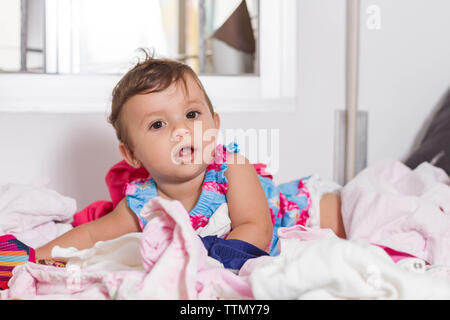 Vêtements fille en désordre sur le dessus du lit de sa mère Banque D'Images