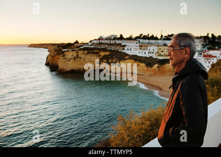 Vue latérale d'happy man looking at sea par ville Banque D'Images