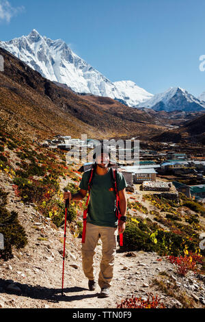 Male hiker avec pôle randonnées en montagne à pied contre le ciel bleu au parc national de Sagarmatha Banque D'Images