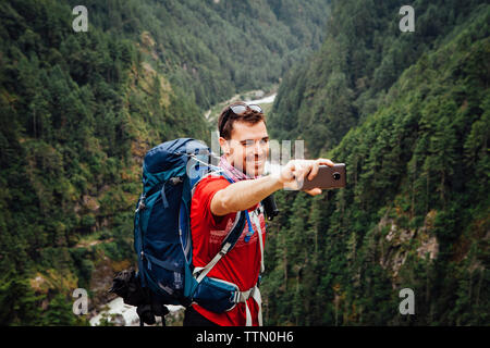 Male hiker selfies prenant en se tenant sur le parc national de Sagarmatha à la montagne Banque D'Images