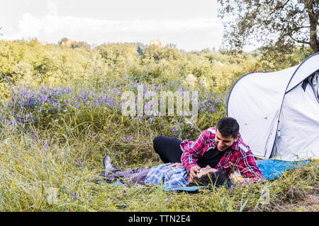 Romantic couple relaxing on blanket at camping en forêt Banque D'Images