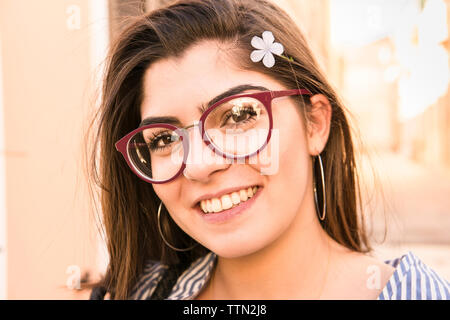 Close-up portrait of smiling woman wearing flower Banque D'Images