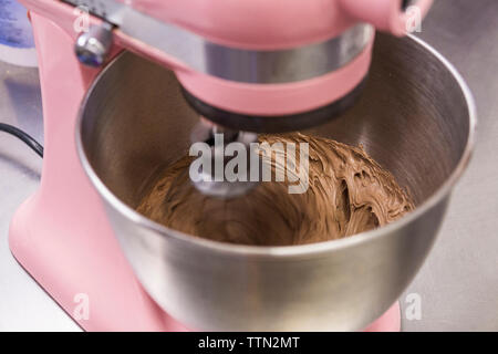 High angle close-up de la pâte au chocolat au mélange dans le mélangeur de laboratoire au comptoir de cuisine Banque D'Images