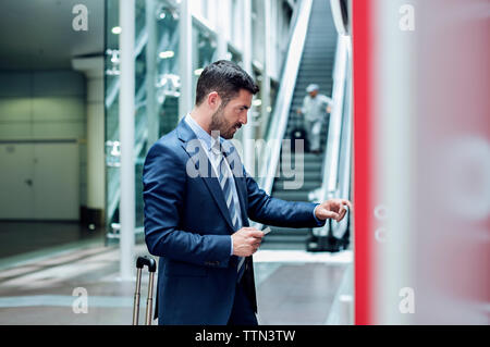 Homme d'affaires utilisant ATM dans la station de métro Banque D'Images