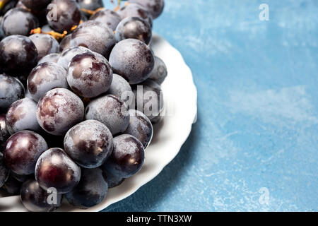 Tas de raisins noirs sur une plaque blanche Banque D'Images