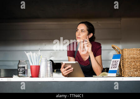 Femme sérieuse fournisseur avec tablet computer in camion alimentaire Banque D'Images