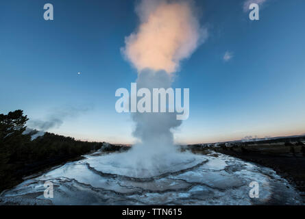 Machine à vapeur de geyser émettant sur fond de ciel bleu au crépuscule Banque D'Images