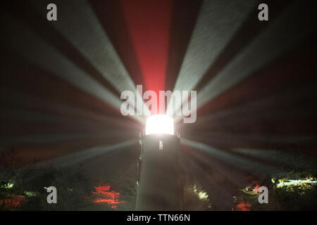 Low angle view of émettant des faisceaux lumineux de lighthouse contre Sky at Night Banque D'Images