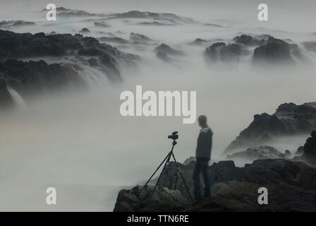 Image composite numérique du randonneur regardant Thor est bien debout sur des rochers Banque D'Images