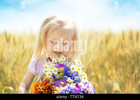 Petite fille avec bouquet de fleurs dans le domaine Banque D'Images