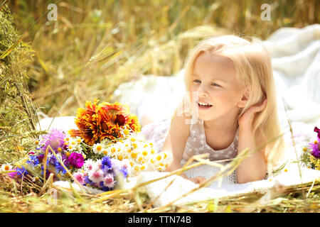 Petite fille avec bouquet de fleurs dans le domaine Banque D'Images