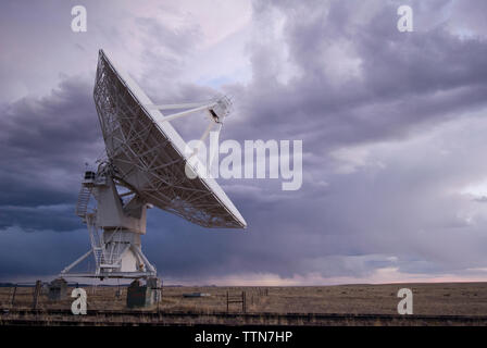 Antenne parabolique sur le field against cloudy sky Banque D'Images