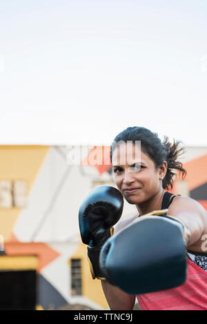 Portrait of female boxer sport extérieur contre le ciel clair Banque D'Images