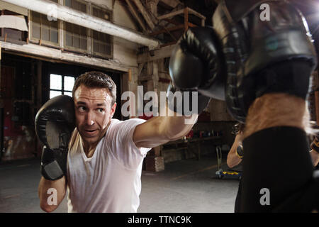Déterminé male boxer exerçant en salle de sport Banque D'Images