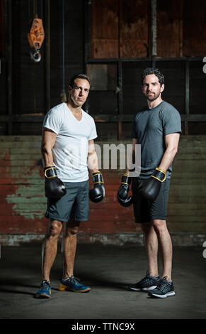 Portrait de l'homme confiant boxers standing in gym Banque D'Images