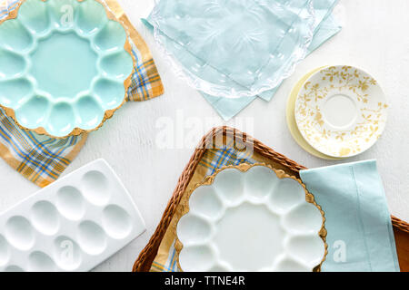 Vue en grand angle des assiettes vides en forme d'œuf avec serviettes et plateau sur table à la maison Banque D'Images