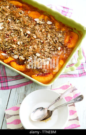 Vue rapprochée en grand angle du dessert pêche dans la casserole sur la table à la maison Banque D'Images