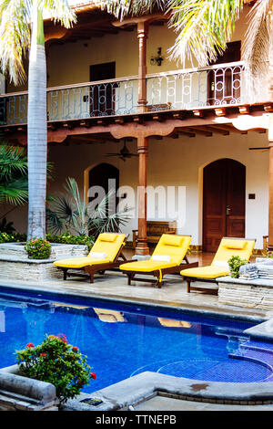 Chaises de salon par la piscine de l'hôtel de luxe Banque D'Images