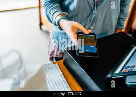 Portrait de la clientèle féminine au paiement mobile store Banque D'Images