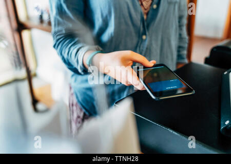 Portrait de la clientèle féminine au paiement mobile store Banque D'Images