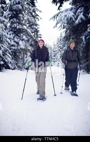 Couple en raquettes à neige dans la forêt Banque D'Images