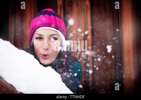 Portrait of young woman blowing snow Banque D'Images