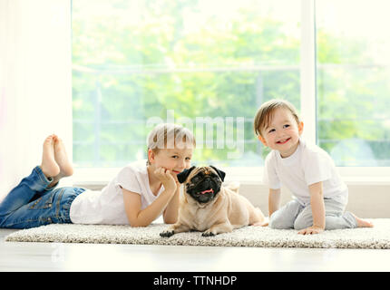 Jolie fille et garçon avec pug in room Banque D'Images