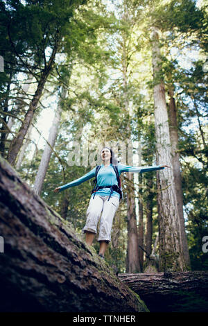 Young woman balancing on tree log Banque D'Images