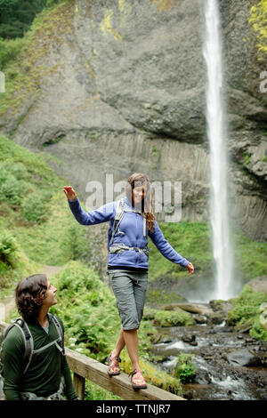 L'homme à la petite amie à marcher sur main courante en cascade Banque D'Images