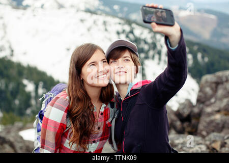 Amies en tenant debout sur mountain selfies Banque D'Images