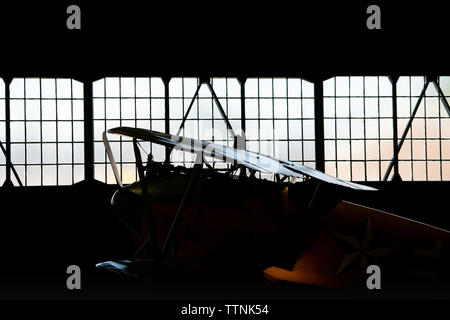 Albatros DV replica allemand historique WW1 silhouette biplan / RIM-éclairé à l'intérieur d'un hangar. Tel que piloté par le Baron rouge, Manfred von Richthofen Banque D'Images