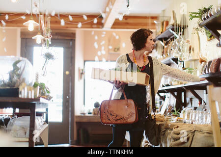 Customer examining plants in garden centre Banque D'Images