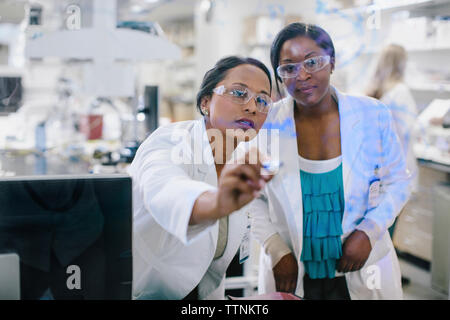 Les femmes médecins discuter lors de l'écriture sur la fenêtre de verre dans la salle médicale Banque D'Images