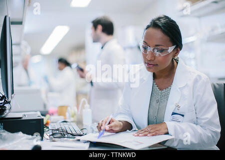 Femme médecin travaillant au bureau avec vos collègues en arrière-plan Banque D'Images
