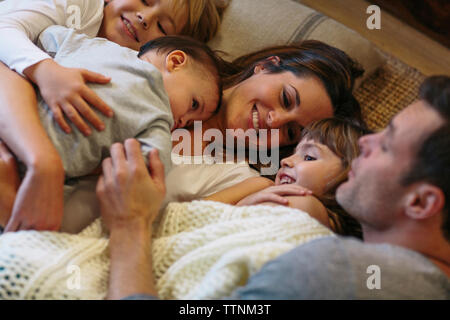 Portrait d'enfants avec les parents de dormir sur le tapis à la maison Banque D'Images