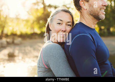 Portrait of woman embracing man at riverbank Banque D'Images