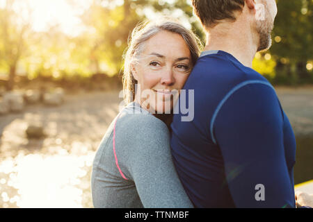 Woman tout en embrassant l'homme à riverbank Banque D'Images