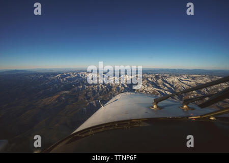 Portrait de l'avion survolant l'encontre du paysage au coucher du soleil Ciel clair Banque D'Images