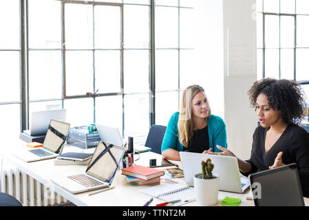 High angle view of businesswomen talking while working at office Banque D'Images