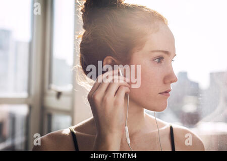 Close-up of woman listening music at home Banque D'Images